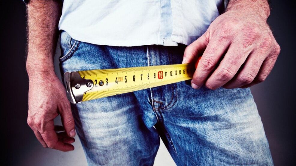 Man measures penis after enlargement with gel